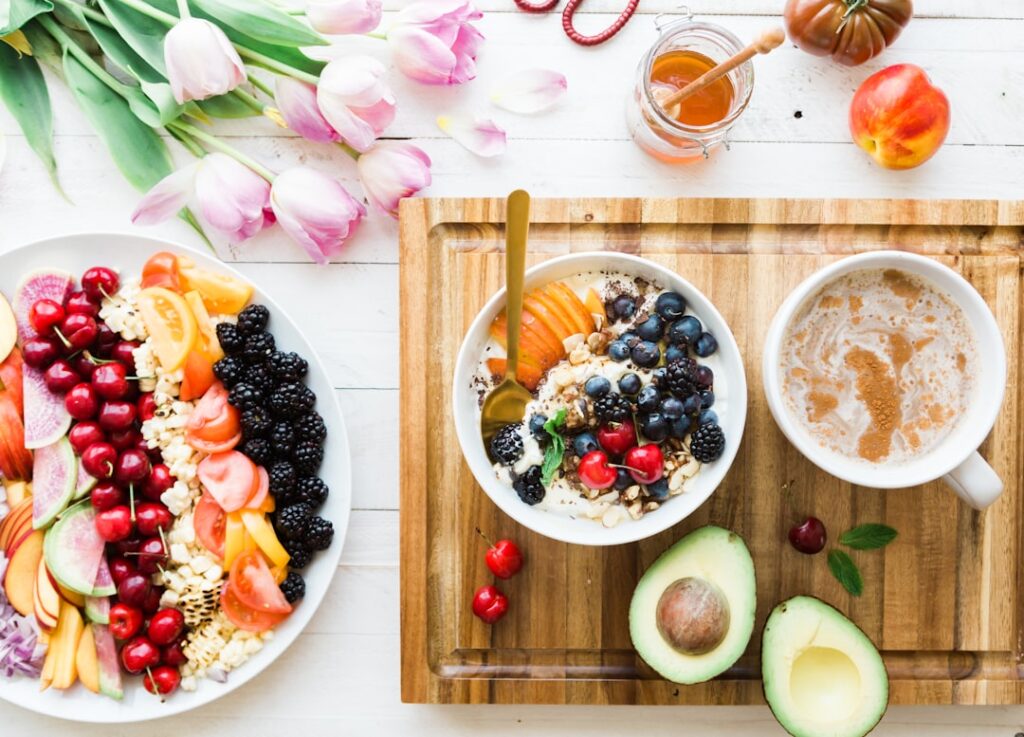A kitchen table with a bowl of oatmeal, berries, nuts, and a glass of water in morning sunlight.