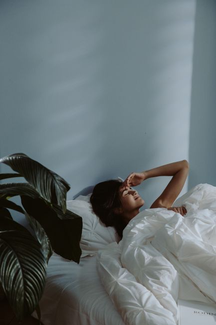 A peaceful bedroom at night with soft lighting, blackout curtains, a mug of herbal tea, and a small bedside humidifier.